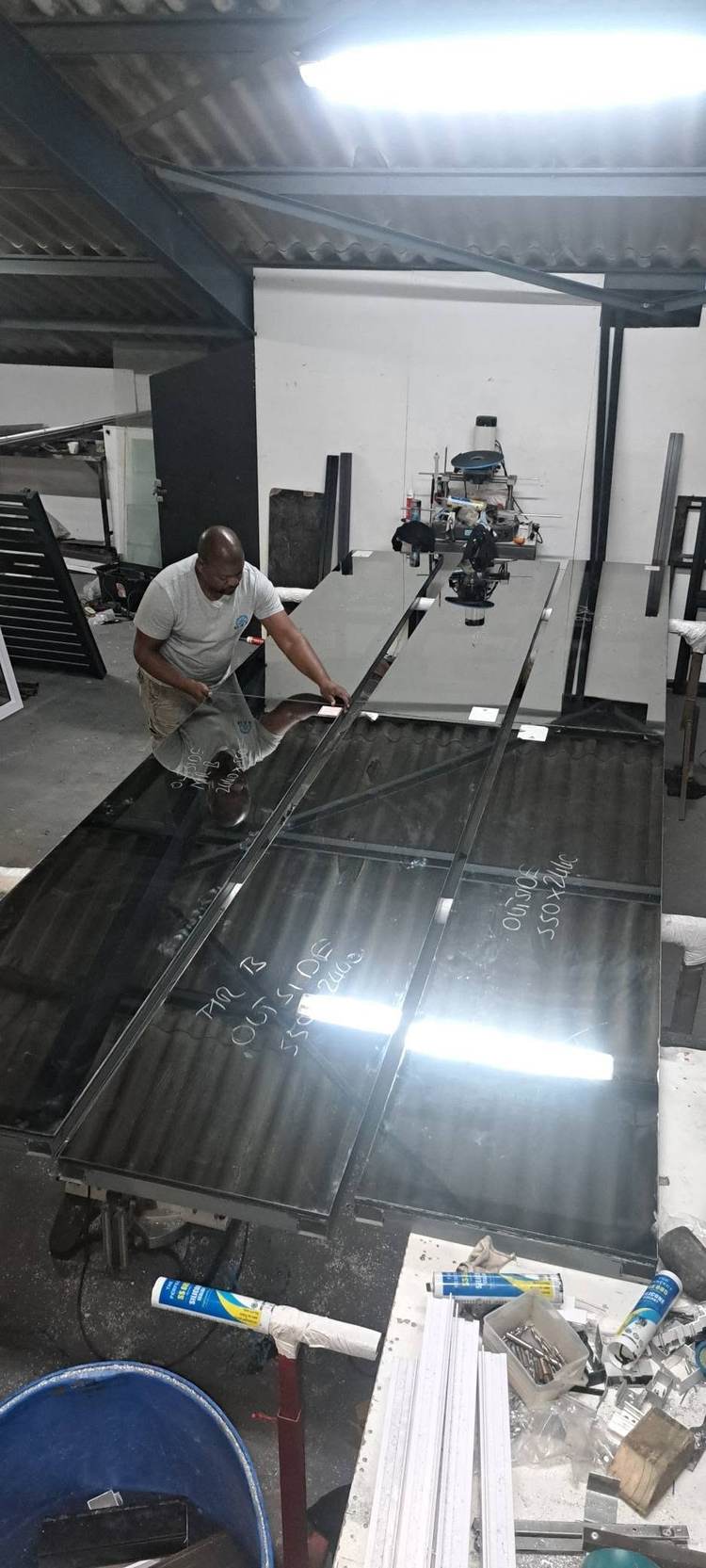 An installer laying glass on the workshop bench